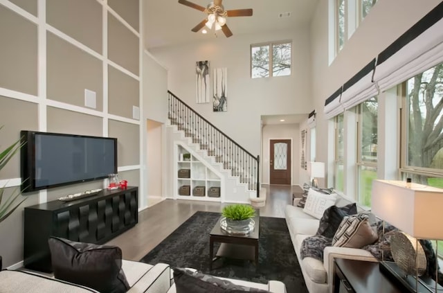 229 Regatta Trl, Leander, TX 78641 - living area featuring plenty of natural light, stairs, ceiling fan, wood finished floors, and a towering ceiling