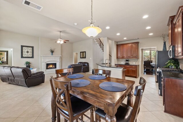 1802 Tall Chief, Leander, TX 78641 - dining room featuring light tile patterned flooring, a warm lit fireplace, ceiling fan, recessed lighting, and stairway