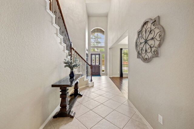 1802 Tall Chief, Leander, TX 78641 - foyer entrance with stairway, light tile patterned floors, a high ceiling, and a textured wall