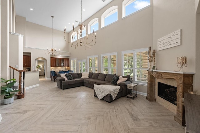 4605 Bat Falcon Dr, Austin, TX 78738 - living room featuring a chandelier, a fireplace, a high ceiling, healthy amount of natural light, and arched walkways