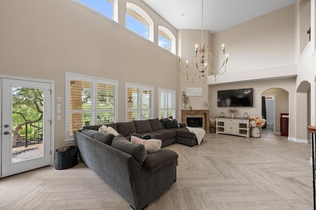 4605 Bat Falcon Dr, Austin, TX 78738 - living area featuring a towering ceiling, a chandelier, arched walkways, and a fireplace