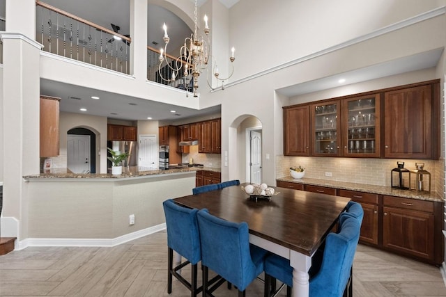 4605 Bat Falcon Dr, Austin, TX 78738 - dining area featuring arched walkways, a chandelier, and a high ceiling