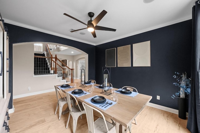 4605 Bat Falcon Dr, Austin, TX 78738 - dining area with arched walkways, stairway, a ceiling fan, light wood-type flooring, and crown molding