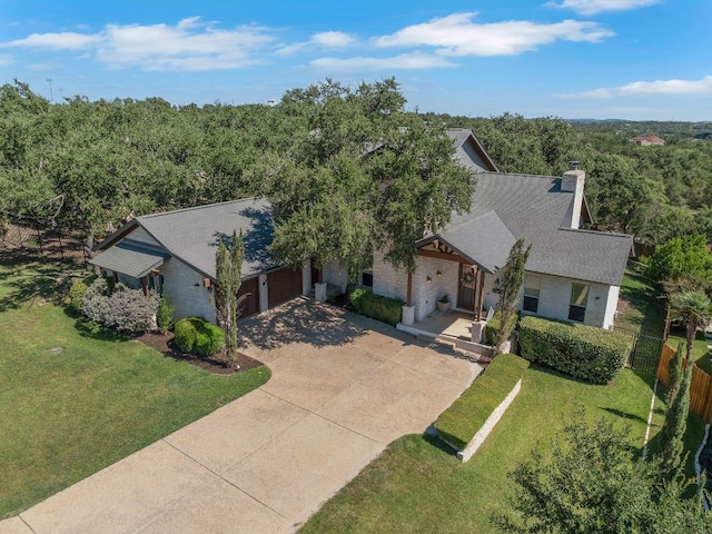 2705 Pyramid Dr, Austin, TX 78734 - view of front of home featuring driveway, an attached garage, a chimney, and a shingled roof