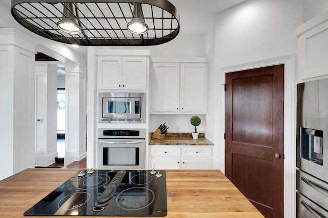 2705 Pyramid Dr, Austin, TX 78734 - kitchen with stainless steel appliances, butcher block counters, ornate columns, and white cabinets