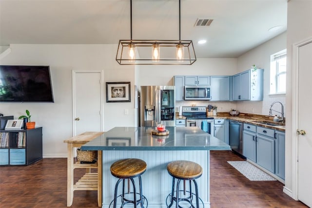 18701 Golden Eagle Way, Elgin, TX 78621 - kitchen with stainless steel appliances, blue cabinets, dark countertops, and recessed lighting