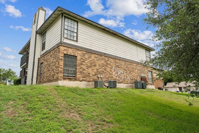 11303 Nicole Cv, Austin, TX 78753 - view of side of property with a chimney, brick siding, and a yard