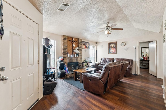 11303 Nicole Cv, Austin, TX 78753 - living area featuring a textured ceiling, ceiling fan, wood finished floors, and a brick fireplace