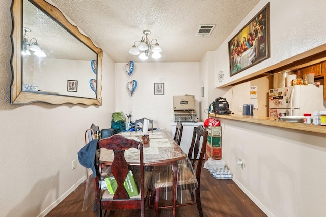 11303 Nicole Cv, Austin, TX 78753 - dining area with wood finished floors, a textured ceiling, and a chandelier