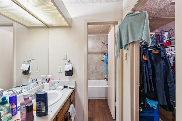 11303 Nicole Cv, Austin, TX 78753 - full bathroom featuring vanity, wood finished floors, a walk in closet, and shower / bathtub combination