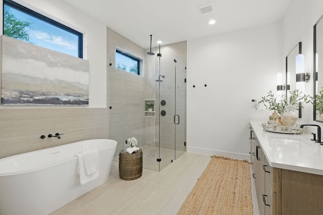 2711 Pegram, Austin, TX 78757 - full bath with vanity, a shower stall, a freestanding bath, tile patterned flooring, and tile walls