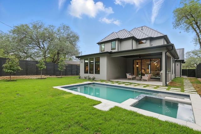 2711 Pegram, Austin, TX 78757 - back of property featuring stucco siding, a fenced backyard, an outdoor hangout area, a pool with connected hot tub, and a patio area