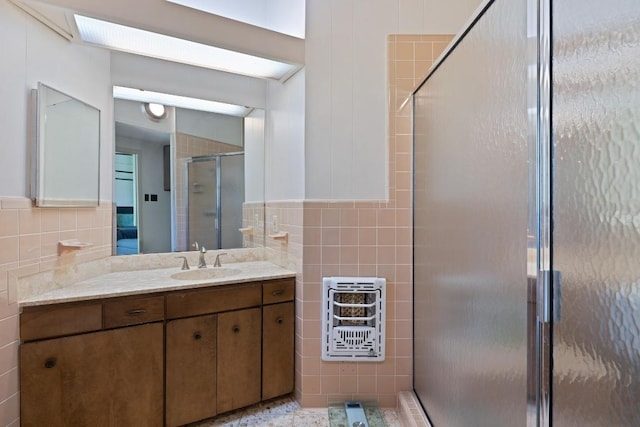 2401 Manana St, Austin, TX 78730 - full bath with tile walls, heating unit, vanity, and a stall shower