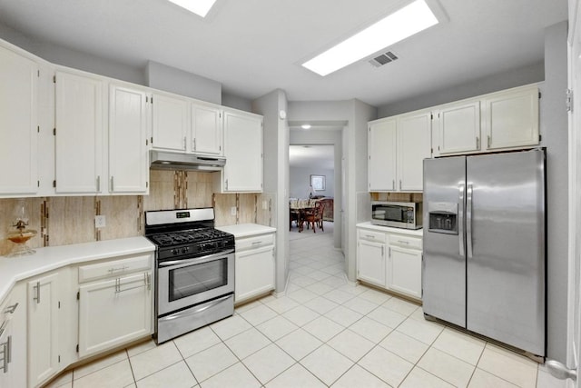9602 Tea Rose Trl, Austin, TX 78748 - kitchen with appliances with stainless steel finishes, under cabinet range hood, white cabinetry, light countertops, and decorative backsplash