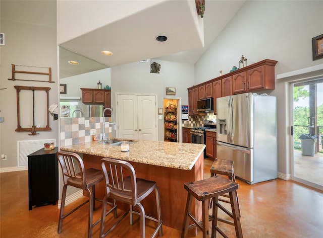 209 Old Sayers Rd, Elgin, TX 78621 - kitchen with stainless steel appliances, decorative backsplash, finished concrete floors, a high ceiling, and a breakfast bar area