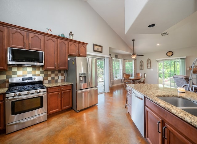 209 Old Sayers Rd, Elgin, TX 78621 - kitchen featuring stainless steel appliances, decorative backsplash, ceiling fan, light stone counters, and concrete flooring