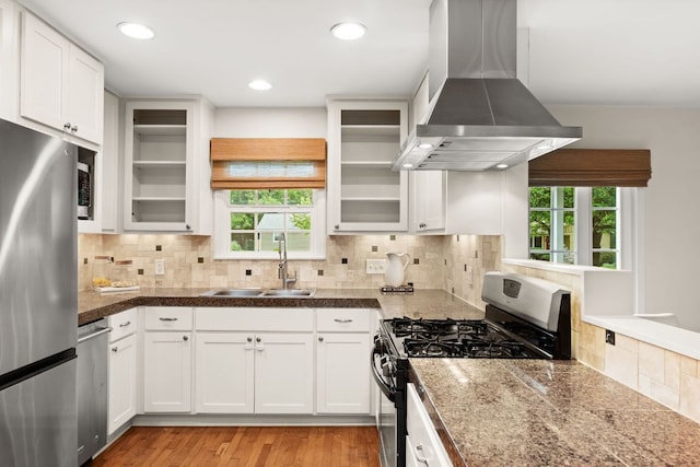 5212 Valley Oak Dr, Austin, TX 78731 - kitchen with stainless steel appliances, wall chimney range hood, healthy amount of natural light, white cabinetry, and recessed lighting