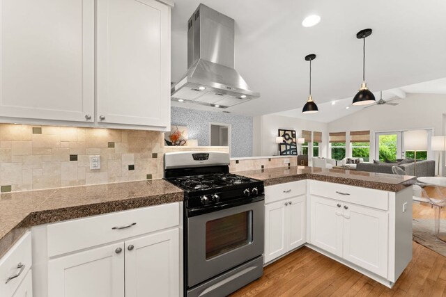 5212 Valley Oak Dr, Austin, TX 78731 - kitchen featuring stainless steel gas range, island range hood, tile countertops, light wood-style flooring, and lofted ceiling