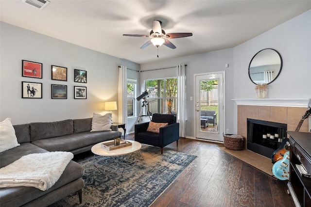 9204 Brents Elm Dr, Austin, TX 78744 - living area with dark wood finished floors, a ceiling fan, and a tile fireplace