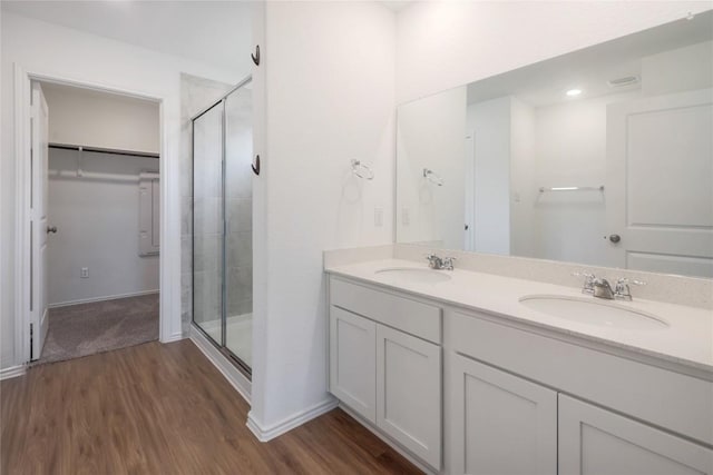 421 Bluejack Way, Hutto, TX 78634 - bathroom with a shower stall, double vanity, wood finished floors, and a spacious closet