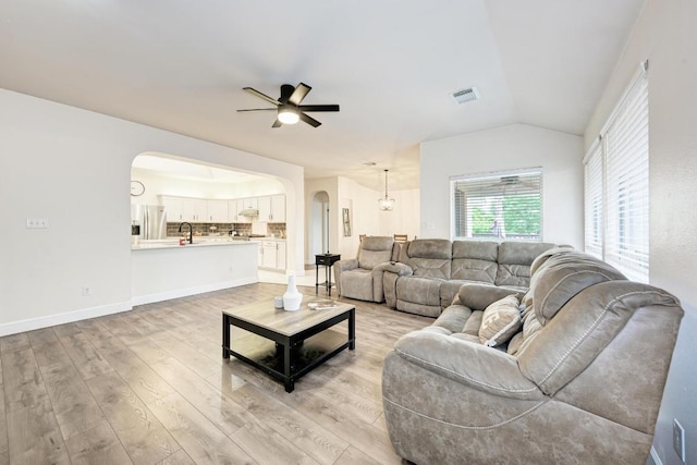 500 Olympic Dr, Pflugerville, TX 78660 - living room featuring arched walkways, a ceiling fan, light wood-style flooring, and vaulted ceiling