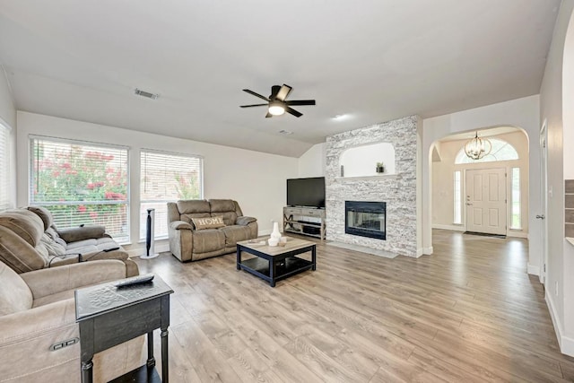 500 Olympic Dr, Pflugerville, TX 78660 - living area with arched walkways, ceiling fan, light wood-style floors, lofted ceiling, and a fireplace