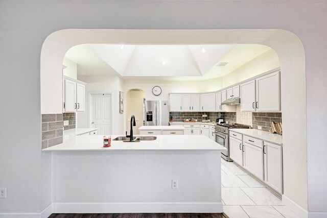 500 Olympic Dr, Pflugerville, TX 78660 - kitchen with stainless steel appliances, under cabinet range hood, arched walkways, and decorative backsplash