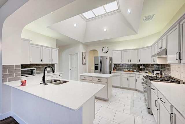 500 Olympic Dr, Pflugerville, TX 78660 - kitchen with stainless steel appliances, a peninsula, tasteful backsplash, arched walkways, and recessed lighting