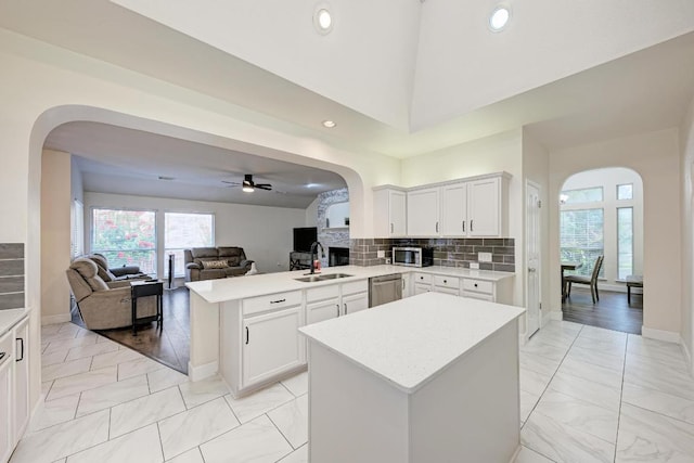 500 Olympic Dr, Pflugerville, TX 78660 - kitchen with arched walkways, stainless steel appliances, light countertops, open floor plan, and recessed lighting