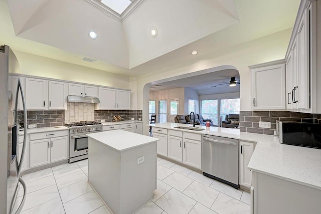 500 Olympic Dr, Pflugerville, TX 78660 - kitchen with stainless steel appliances, arched walkways, under cabinet range hood, a ceiling fan, and light marble finish floors