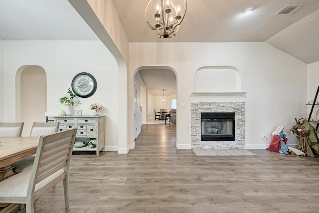 500 Olympic Dr, Pflugerville, TX 78660 - living room featuring arched walkways, a chandelier, wood finished floors, and vaulted ceiling