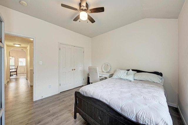 500 Olympic Dr, Pflugerville, TX 78660 - bedroom featuring light wood-type flooring, vaulted ceiling, arched walkways, a closet, and a ceiling fan
