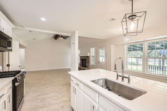 901 Garden Meadow Dr, Georgetown, TX 78628 - kitchen featuring black range with gas cooktop, stainless steel microwave, open floor plan, light countertops, and lofted ceiling
