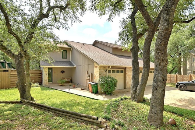 2500 Dana Cv, Austin, TX 78746 - rear view of house with an attached garage, a shingled roof, stone siding, and concrete driveway