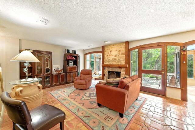 2500 Dana Cv, Austin, TX 78746 - living area featuring plenty of natural light, a textured ceiling, and a stone fireplace