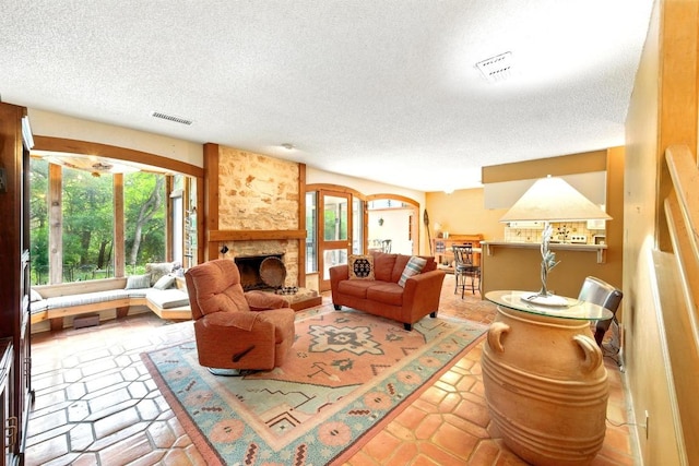 2500 Dana Cv, Austin, TX 78746 - tiled living area with a textured ceiling and a stone fireplace