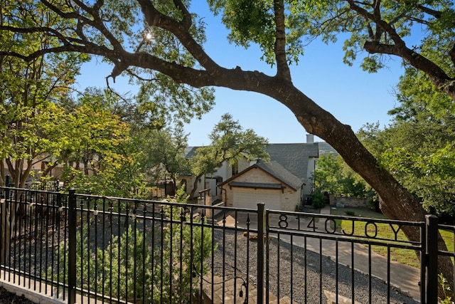 8140 Joy Rd, Volente, TX 78641 - view of property hidden behind natural elements with a garage, a shingled roof, and driveway
