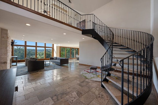 8140 Joy Rd, Volente, TX 78641 - staircase with stone tile flooring, recessed lighting, and a high ceiling
