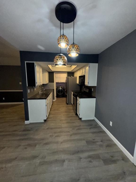 607 Garden Path Cv, Round Rock, TX 78664 - kitchen with black microwave, dark countertops, gas stove, white cabinetry, and washer / clothes dryer