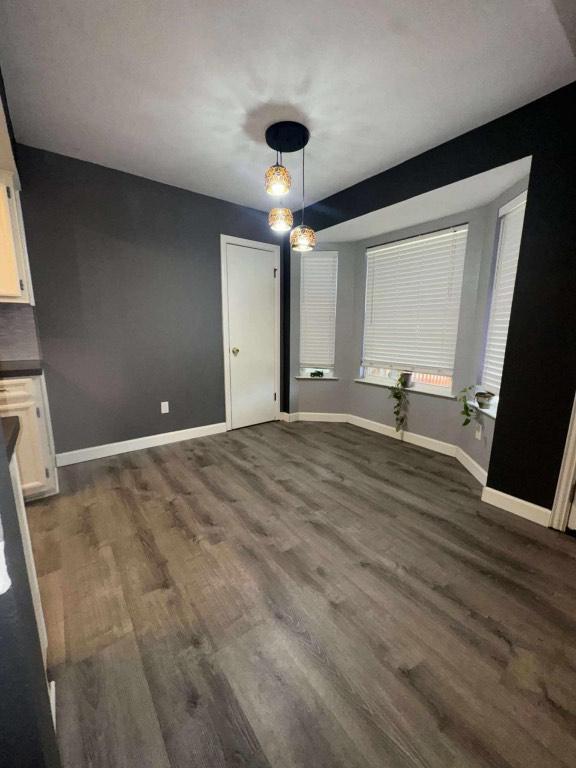 607 Garden Path Cv, Round Rock, TX 78664 - unfurnished dining area with baseboards and dark wood-style flooring