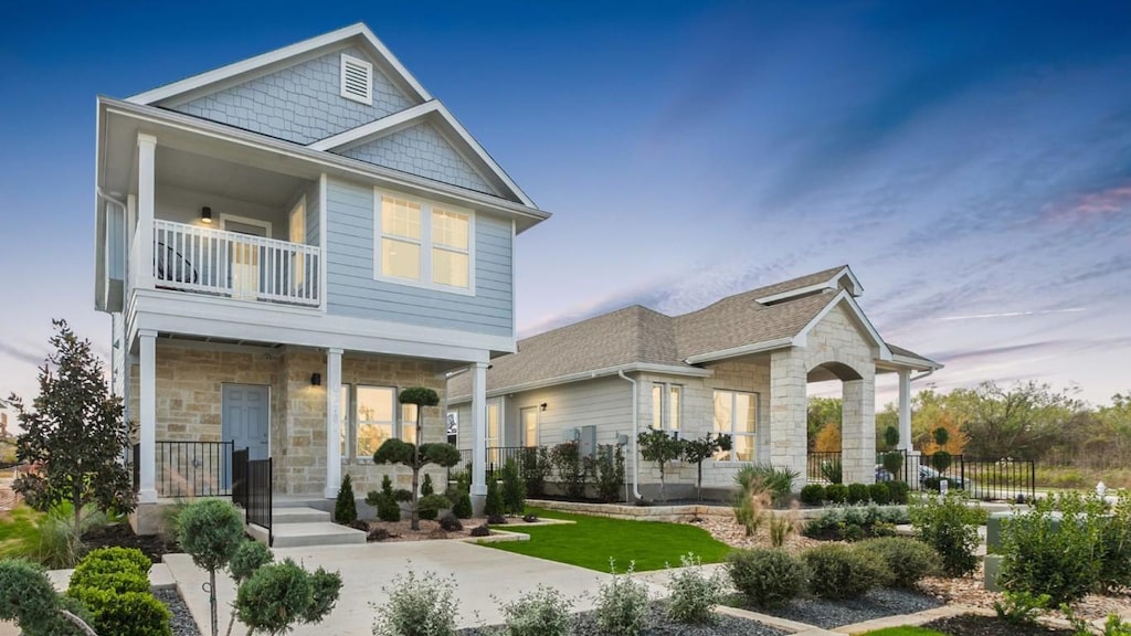 9900 Petrichor Blvd, Manor, TX 78653 - view of front of property with stone siding, a balcony, and a porch