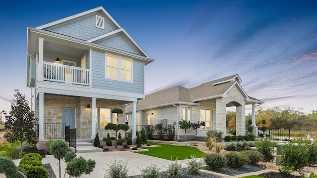 9900 Petrichor Blvd, Manor, TX 78653 - view of front of property with stone siding, a balcony, and a porch