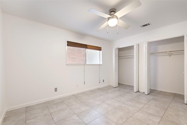 2122 Hancock Dr Unit 103, Austin, TX 78756 - unfurnished bedroom featuring two closets, light tile patterned floors, and a ceiling fan