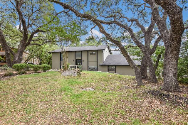 6203 Olympic Overlook Dr, Austin, TX 78746 - back of house featuring stucco siding and a yard