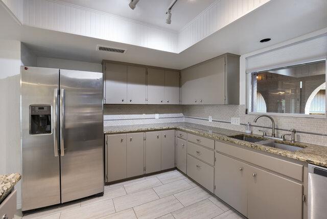 6203 Olympic Overlook Dr, Austin, TX 78746 - kitchen featuring stainless steel appliances, gray cabinetry, decorative backsplash, track lighting, and light stone counters