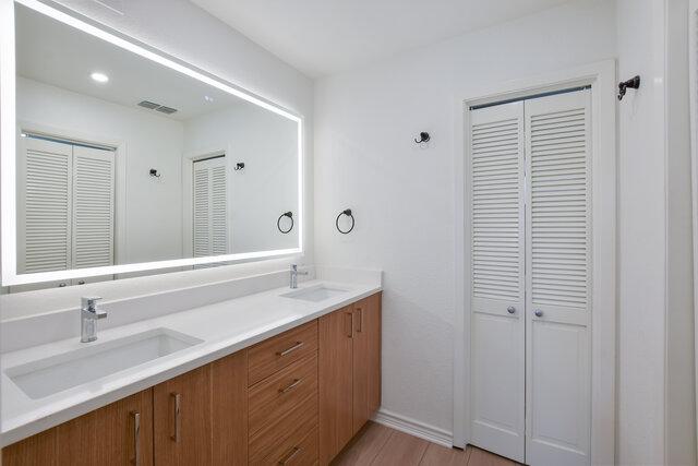 6203 Olympic Overlook Dr, Austin, TX 78746 - full bathroom featuring a closet, double vanity, and wood finished floors