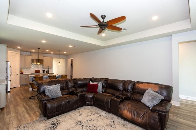 1328 Siena Sunset Rd, Leander, TX 78641 - living area featuring ceiling fan, light wood-style floors, a tray ceiling, and recessed lighting