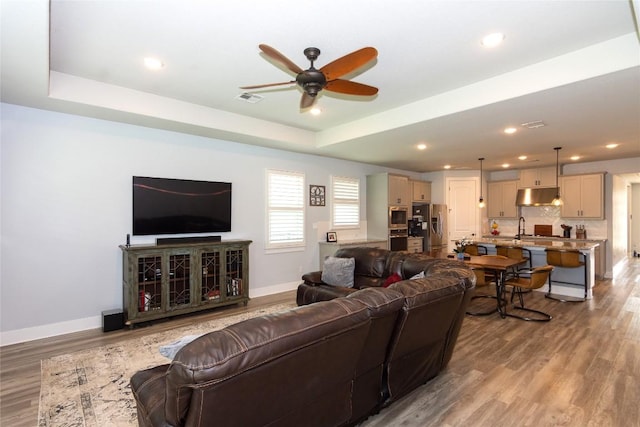 1328 Siena Sunset Rd, Leander, TX 78641 - living area featuring ceiling fan, light wood finished floors, a raised ceiling, and recessed lighting