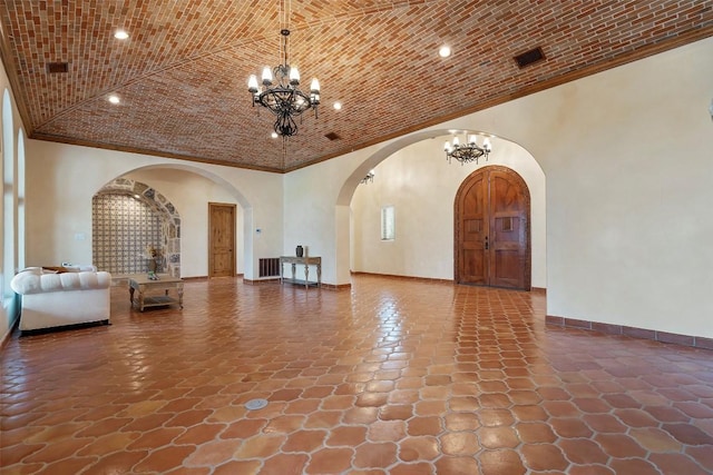 108 Country Vista Ln, Georgetown, TX 78626 - living room featuring a chandelier, arched walkways, ornamental molding, stone finish flooring, and recessed lighting