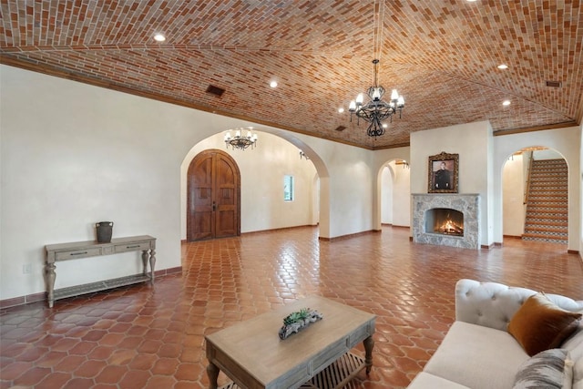 108 Country Vista Ln, Georgetown, TX 78626 - living area featuring arched walkways, a chandelier, brick ceiling, a warm lit fireplace, and recessed lighting